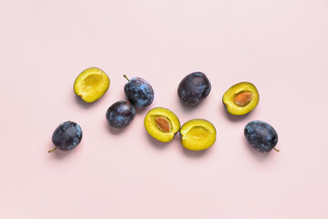 Fresh plums on pink background