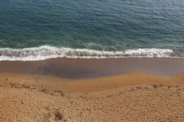 Une vague s'abat sur la plage Saint Eugène à Saint-Marc-sur-mer vue de loin (commune de Saint-Nazaire)