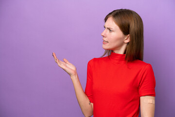 Young English woman wearing band-aids isolated on purple background with surprise facial expression