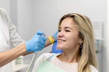 female dentist using water and air syringe tool, process of treatment in dental clinic