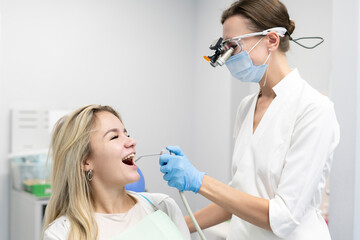 female dentist using water and air syringe tool, process of treatment in dental clinic