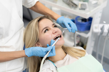 dentist doctor treats a patient's teeth, uses a drill to drill a tooth