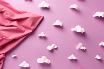 Pink paper airplane on pink background with white clouds scattered around