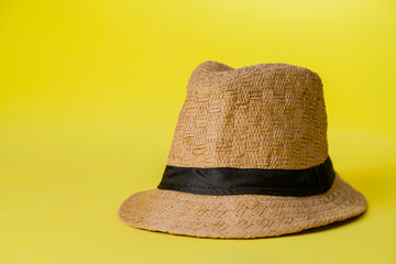 Straw hat on yellow background with summer theme. Space for text. Hat concept. Sombrero concept.