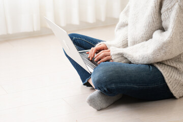 ノートパソコンを操作する若い女性　ライフスタイルイメージ