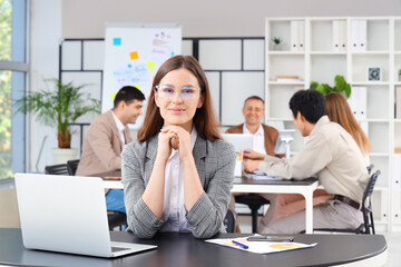 Young businesswoman sitting at table in office