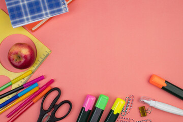 Back to school. Stationery on a salmon color table. Office desk with copy space. Flat lay.