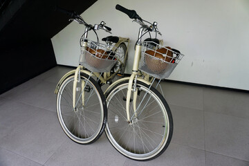 Vintage bicycle with basket and helmet standing on floor