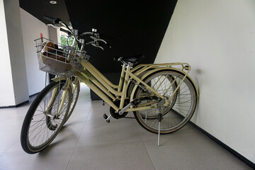 Vintage bicycle with basket and helmet standing on floor