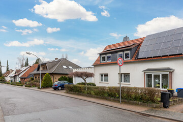 City street of single-family modern houses Germany against blue sky. German suburban small town...