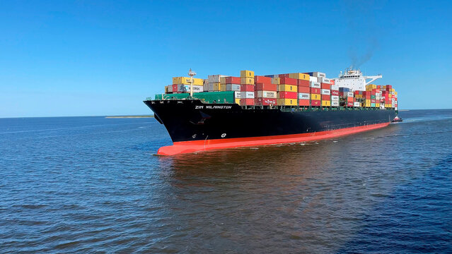 Galveston - April 12, 2023: large container ship ZIM WILMINGTON arriving to the container terminal. She is fully loaded with cargo containers.