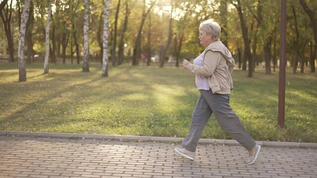 Senior overweight woman running at the park