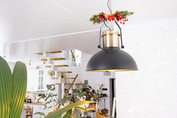 The black lampshade in the industrial loft style is decorated with spruce branches for Christmas...