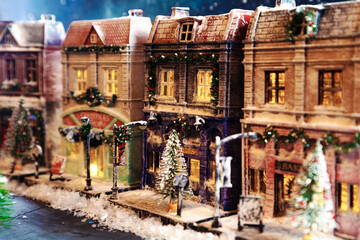 Fototapeta premium Night snow-covered European street decorated for Christmas. Homemade decorated toy houses.