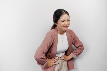 Upset young Asian woman employee suffering from stomachache, overworked at office. Gastritis or...