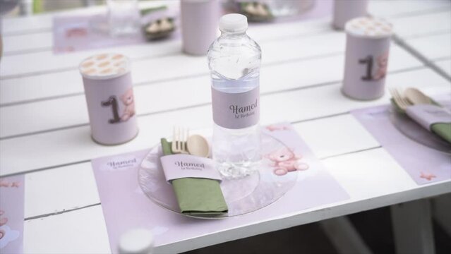 Kid's birthday party, kids birthday party theme teady bear or grizzly bear theme. Kids tiny dinner table with plates and water. Kids outdoor party with balloons and nice decorations.