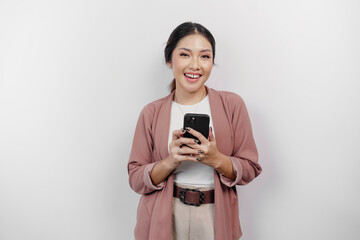 Smiling young Asian woman employee wearing cardigan while holding her phone, isolated by white background