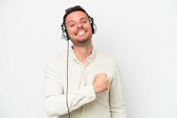 Telemarketer caucasian man working with a headset isolated on white background celebrating a victory