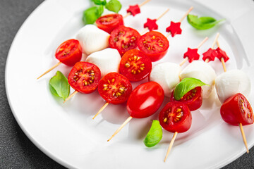 Caprese mozzarella tomato canapes appetizer salad on a skewer finger food eating cooking appetizer meal food snack on the table copy space food background rustic top view