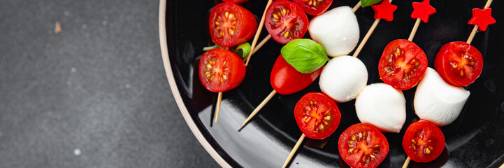 Caprese mozzarella tomato canapes appetizer salad on a skewer finger food eating cooking appetizer meal food snack on the table copy space food background rustic top view