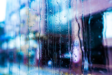 water drops on glass on the background of city street 