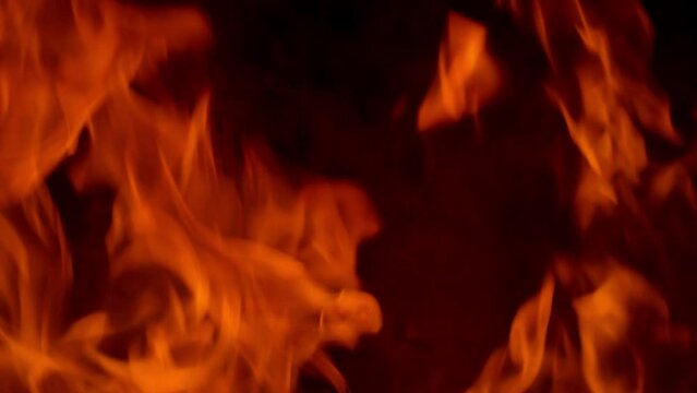 orange flames surge upward on a black background, forming bold fiery shapes with flowing motion, glowing heat, and dramatic contrast in an intense abstract blaze scene.