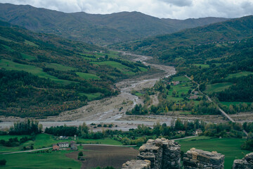 Long river running through green valley near Bardi castle, Italy