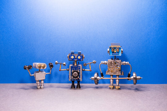 Three robots perform a workout with dumbbells and a barbell. Sports exercise concept, powerlifting