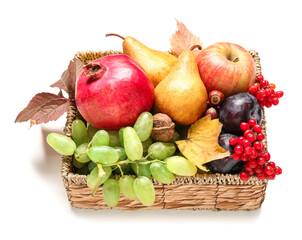 Wicker basket with different fresh fruits on white background