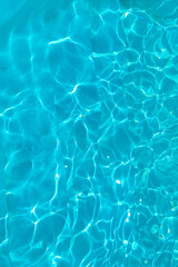 Fototapeta na wymiar Azure transparent texture of water in a blue pool with splashes from the sun