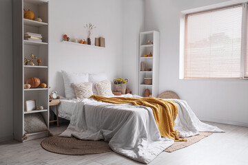 Interior of cozy bedroom with shelf units and pumpkins