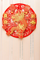 man sticking a Chinese New Year of the Dragon decoration to a wall at vertical composition...