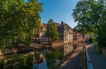 Fototapeta na wymiar Strasbourg, France. Ancient houses of the Petite France district on the embankment of the Ille River in the early morning.