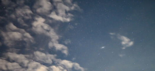 Rozgwieżdżone nocne niebo z galaktyka Andromedy w tle