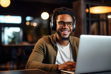 Happy millennial african american man in glasses wearing headphones, enjoying watching educational webinar on laptop. Smiling young mixed race businessman holding video call with clients partners.