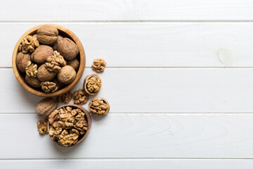 Fresh healthy walnuts in bowl on colored table background. Top view Healthy eating bertholletia concept. Super foods