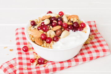 Healthy breakfast food with granola, yogurt, fruits and nuts. Dessert parfait with dried fruits for breakfast