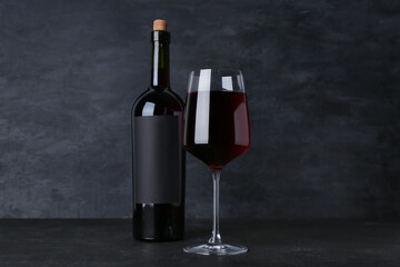 Glass and bottle of exquisite wine on black background