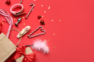 Shopping bag with sex toys and Christmas decor on red background