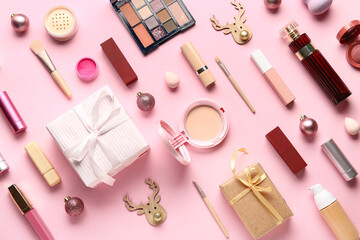 Christmas composition with different makeup products and gift box on pink background