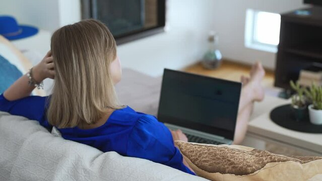 Woman freelancer with laptop works at home.
