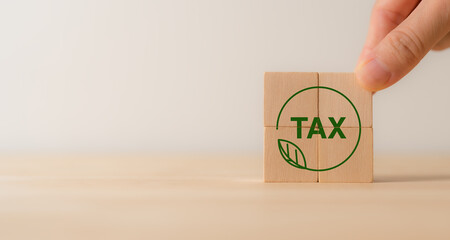 Environmental tax obligation, breaks concept. Wooden blocks with green taxes icons.Using environmental  taxes, carbon tax, environmentally beneficial tax incentives to achieve environmental targets.