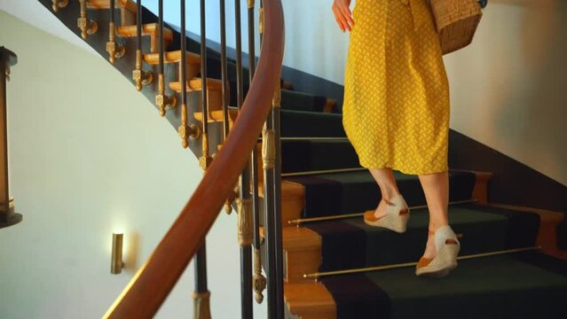 Attractive woman running up vintage stairs indoors