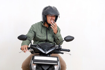 Asian man sneezing while riding a motorcycle. Isolated on white background