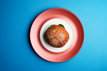 Fresh tasty burger on blue background, top view,