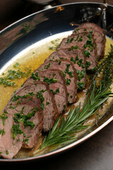 Baked beef meat fillet with herbs and sauce on a plate