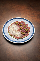 Sliced beef and avocado with grated cheese.