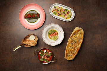 Set of plates of seafood on a brown background, top view.