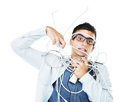 Portrait of man in glasses tangled in wire, cables and isolated on a white background. Face of serious geek wrapped in cord and tech of nerd or electrician, mistake and problem, chaos or struggle