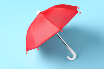 Mini red umbrella on blue background